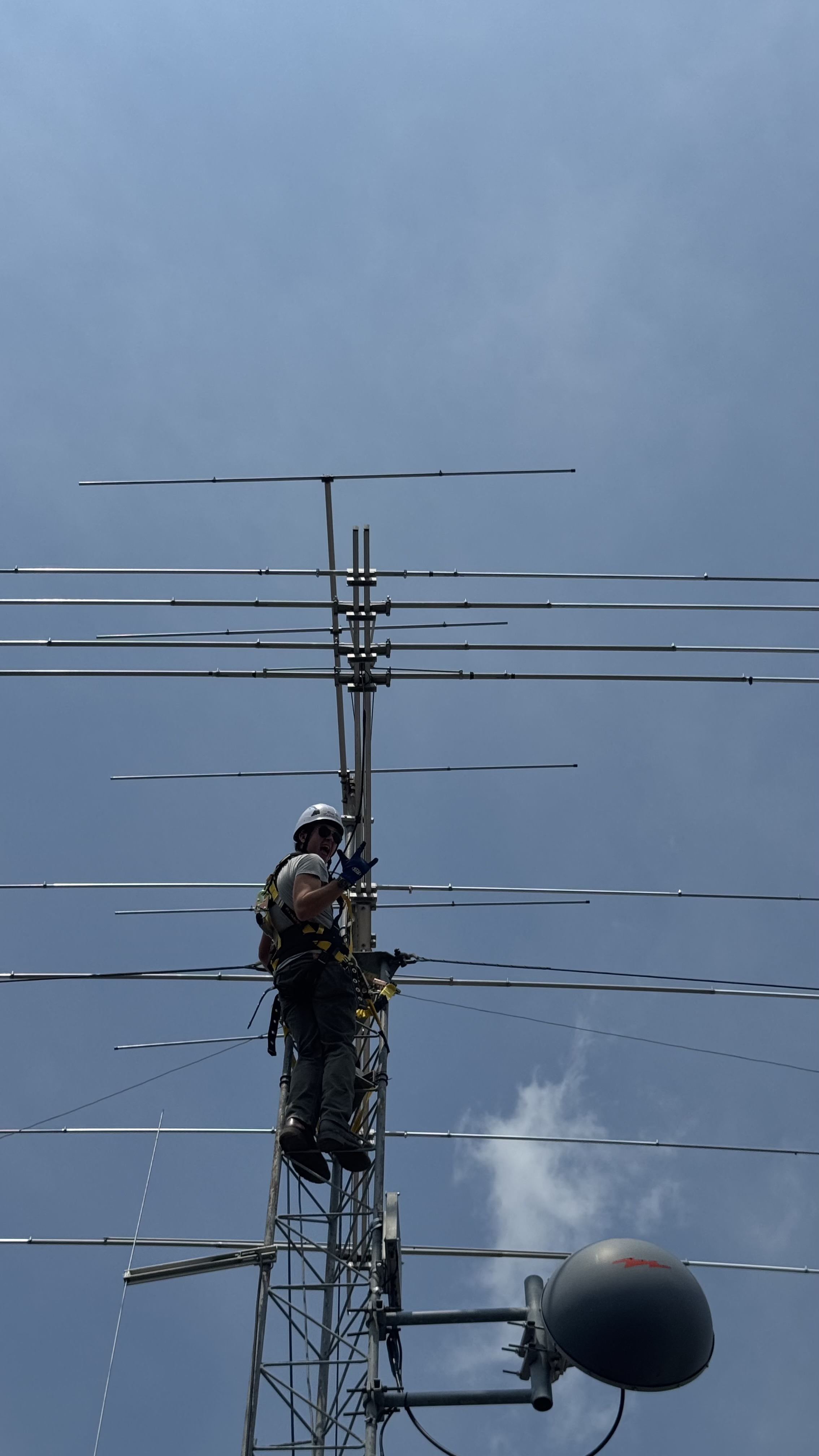 Me atop an antenna tower performing some work on an HF Yagi.
